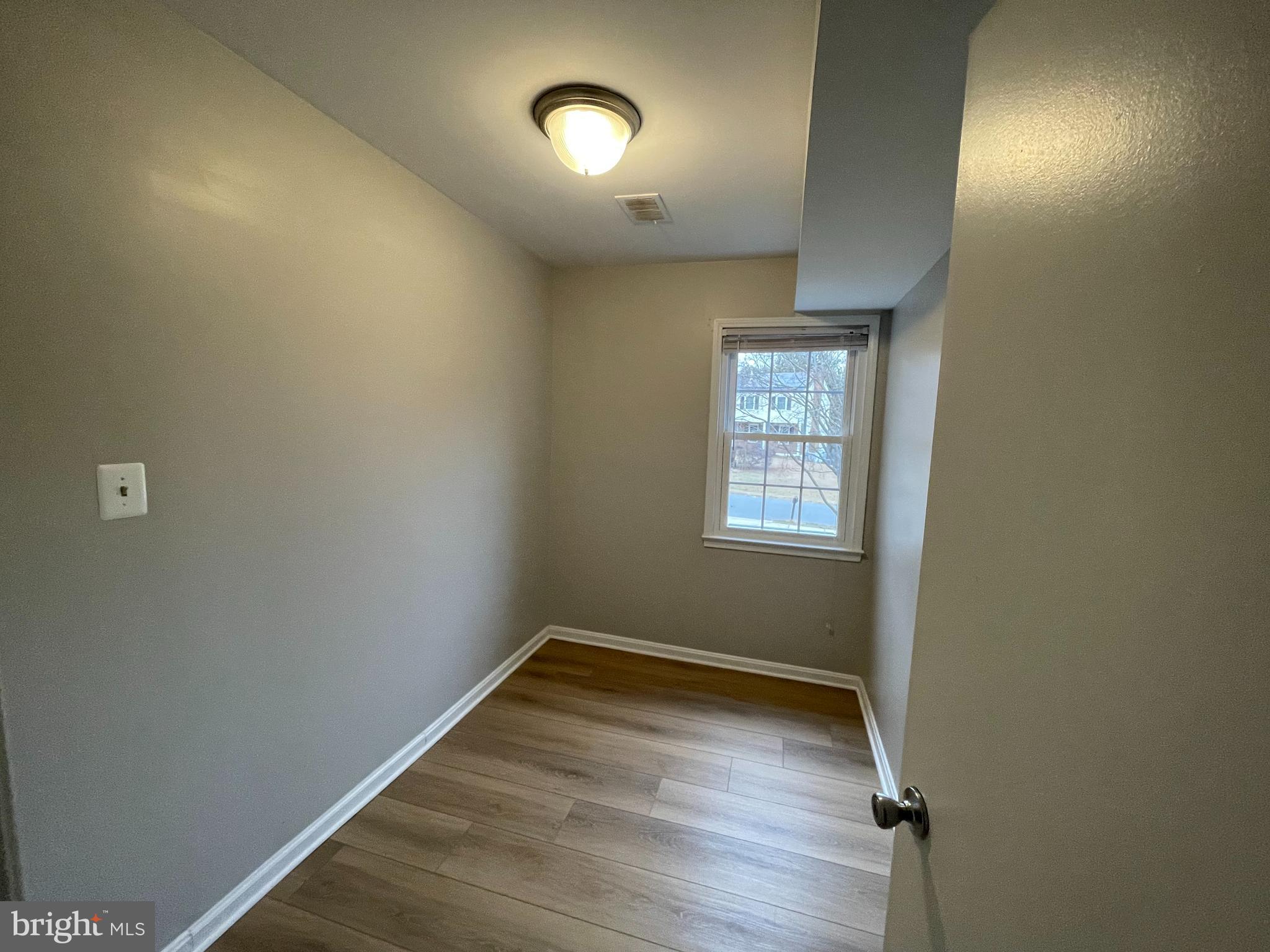 7004 Wick Lane Derwood, MD 20855 - Photo 12 of 19 an empty room with wooden floor and windows