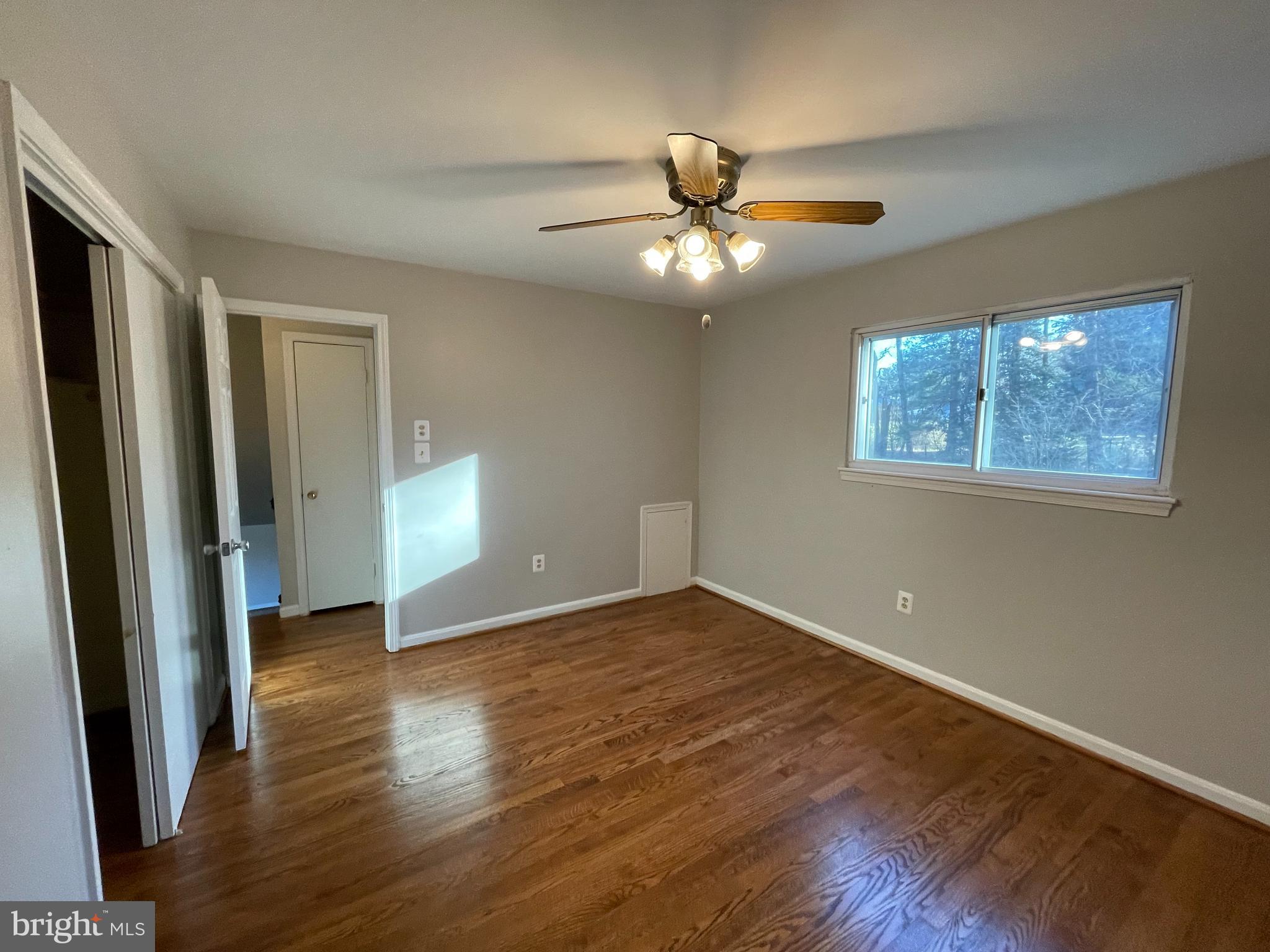 7004 Wick Lane Derwood, MD 20855 - Photo 15 of 19 a view of an empty room with wooden floor and a window