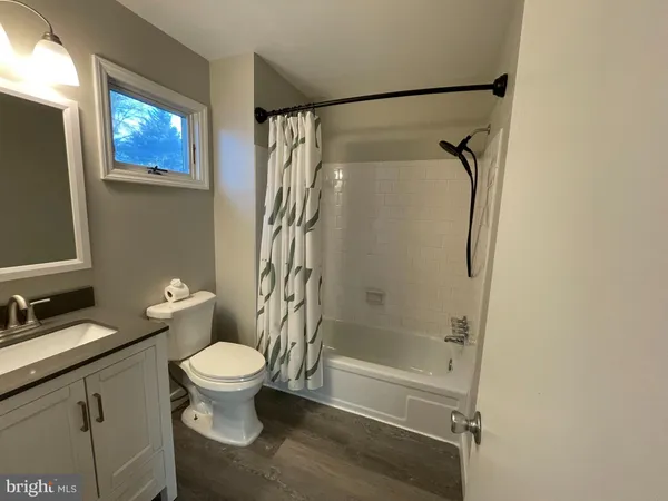 a bathroom with a granite countertop toilet sink and shower