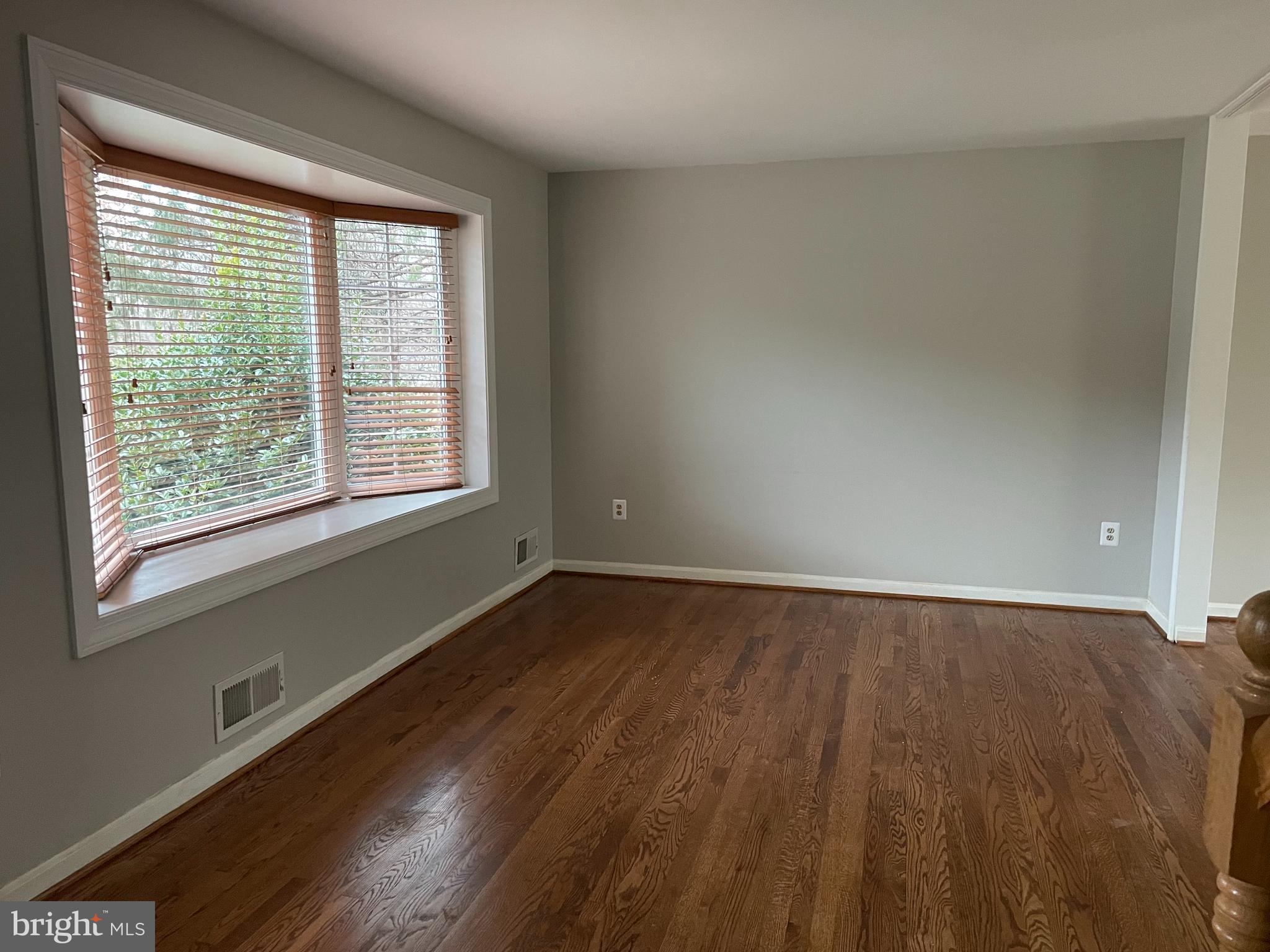 7004 Wick Lane Derwood, MD 20855 - Photo 3 of 19 a view of an empty room with wooden floor and a window