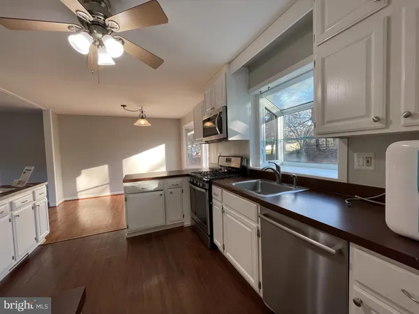 a kitchen with granite countertop a sink stainless steel appliances and cabinets