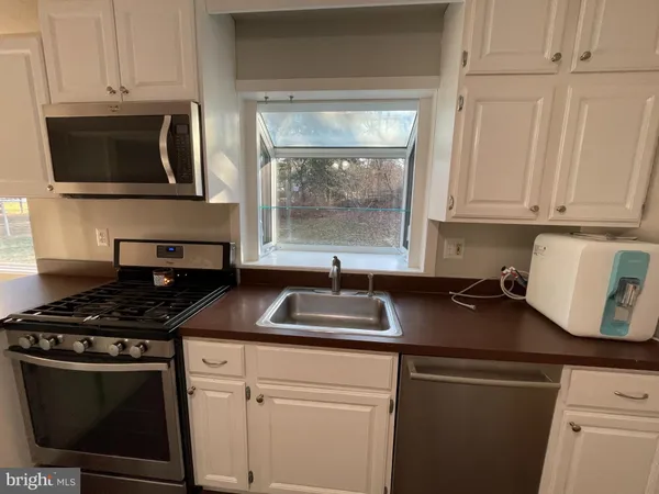 a kitchen with stainless steel appliances granite countertop a sink stove and microwave