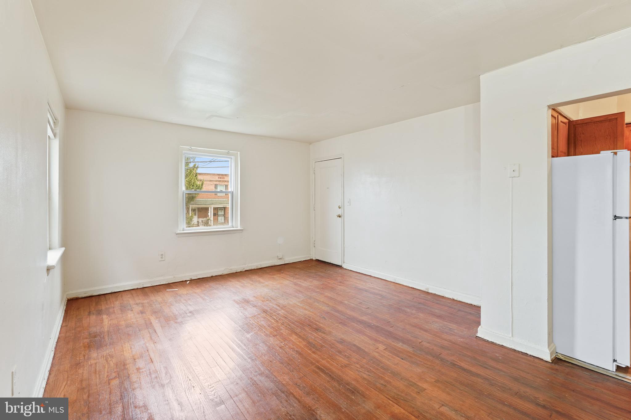 2303 S Street Southeast Washington, DC 20020 - Photo 5 of 18 an empty room with wooden floor a ceiling fan and windows