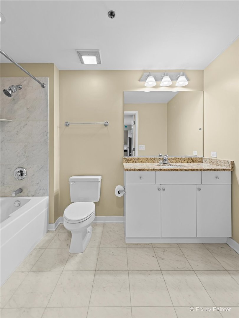 909 West Washington Boulevard, Unit 803 Chicago, IL 60607 - Photo 15 of 21 a spacious bathroom with a granite countertop sink a mirror and a bathtub