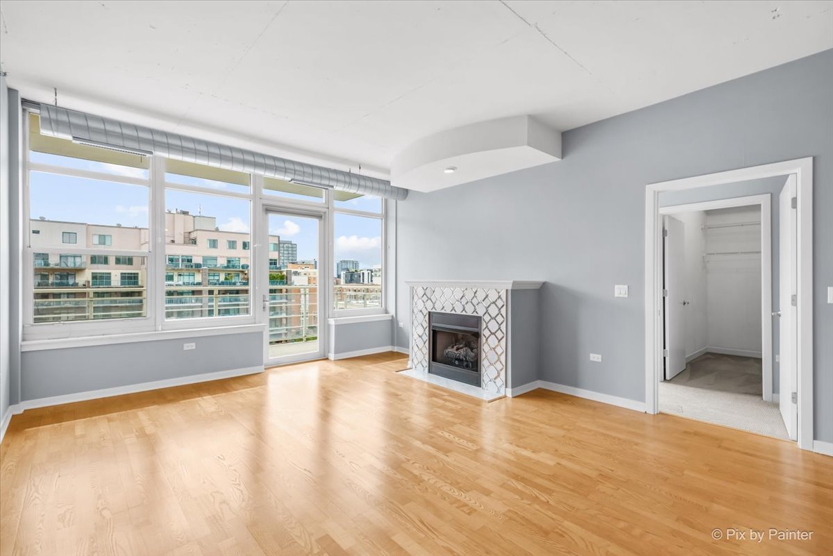 909 West Washington Boulevard, Unit 803 Chicago, IL 60607 - Photo 6 of 21 a view of empty room with wooden floor and fireplace