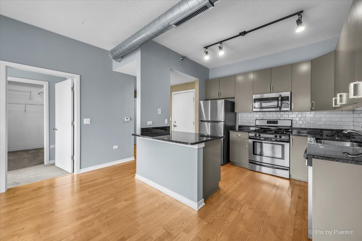 909 West Washington Boulevard, Unit 803 Chicago, IL 60607 - Photo 7 of 21 a kitchen with stainless steel appliances granite countertop a stove top oven a sink and a refrigerator