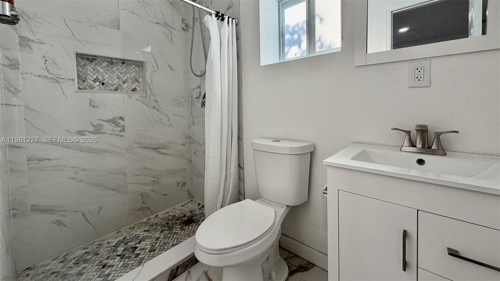 12435 Southwest 42nd Street, Unit 2 Miami, FL 33175 - Photo 3 of 8 a white toilet sitting next to a bathroom sink