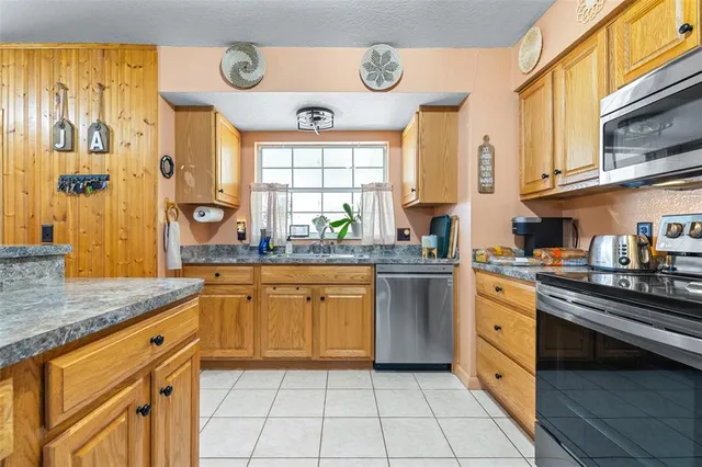 a kitchen with stainless steel appliances granite countertop a stove a sink and a microwave