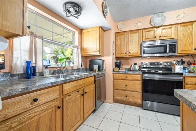 a kitchen with a sink dishwasher and a stove with a dishwasher next to a window