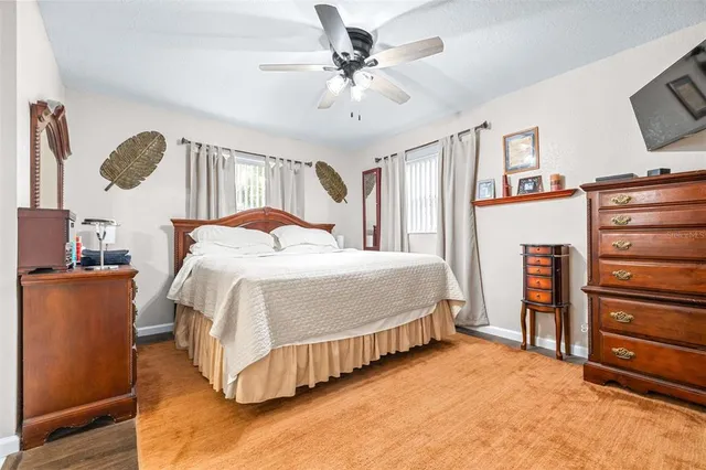 a bedroom with a bed and a flat tv screen on the dresser