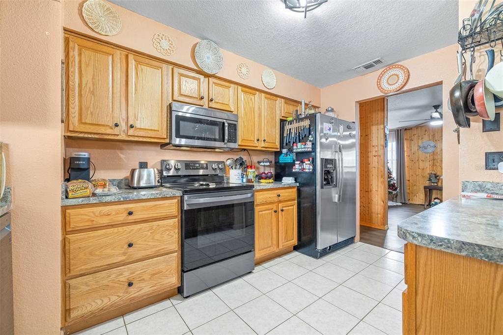 1645 County Road 630 Frostproof, FL 33843 - Photo 9 of 76 a kitchen with granite countertop stainless steel appliances and wooden cabinets