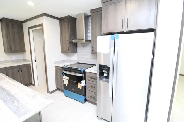 a kitchen with stainless steel appliances granite countertop a refrigerator a sink and a stove