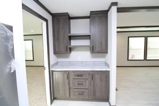a view of kitchen with granite countertop cabinets and window