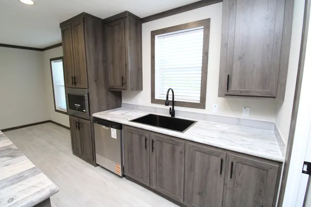 a kitchen with stainless steel appliances granite countertop a sink a stove and a refrigerator