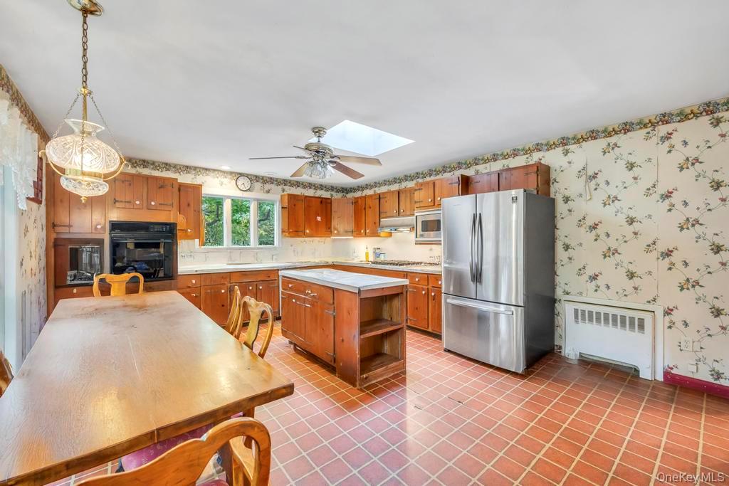 89 Van Brunt Manor Road Setauket, NY 11733 - Photo 25 of 41 a kitchen with refrigerator a stove and a wooden floor