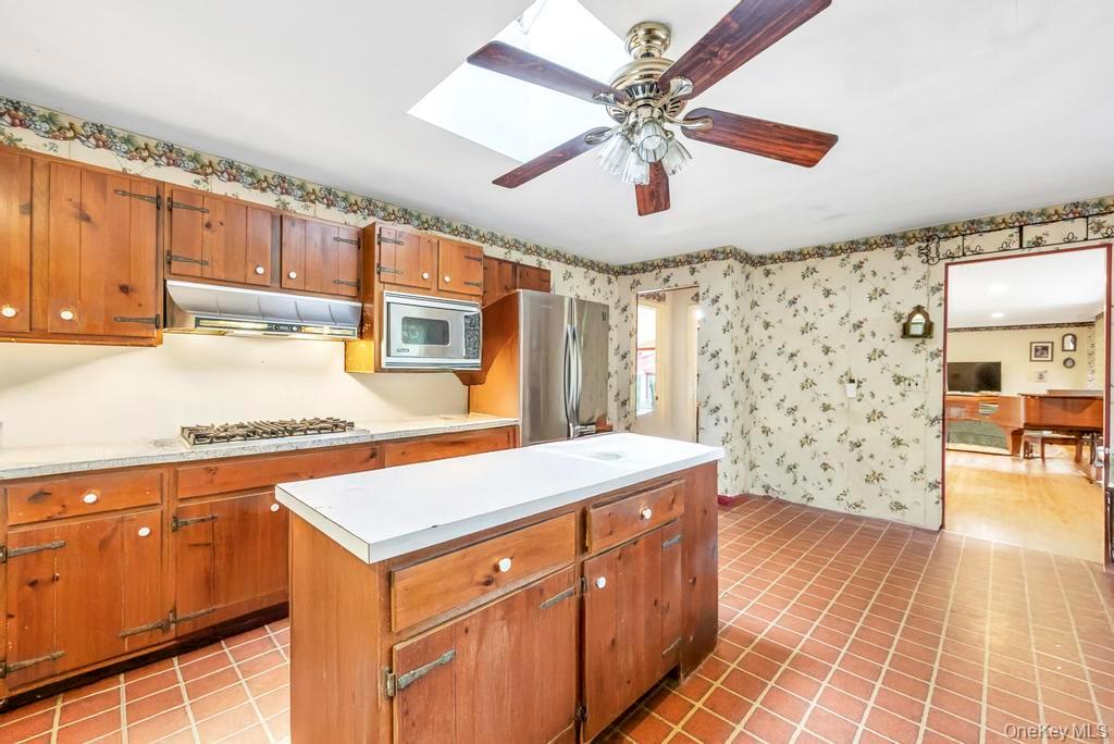 89 Van Brunt Manor Road Setauket, NY 11733 - Photo 27 of 41 a kitchen with a stove a sink a dining table and chairs
