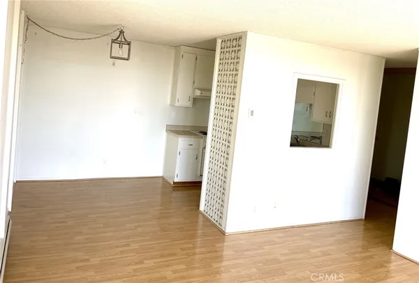 a view of a hallway with wooden floor and a bathroom