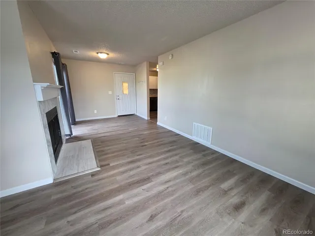 an empty room with wooden floor and entrance