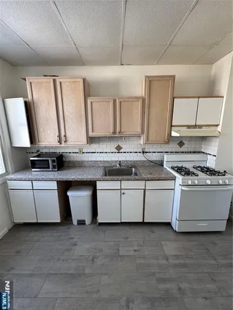 a kitchen with kitchen island granite countertop a sink and white cabinets