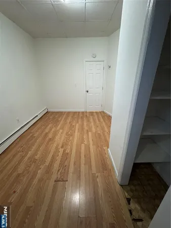 a view of empty room with wooden floor