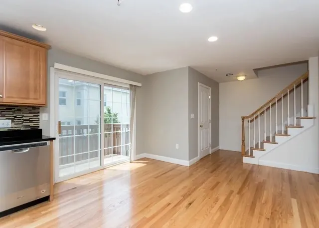 a view of a kitchen with wooden floor and electronic appliances