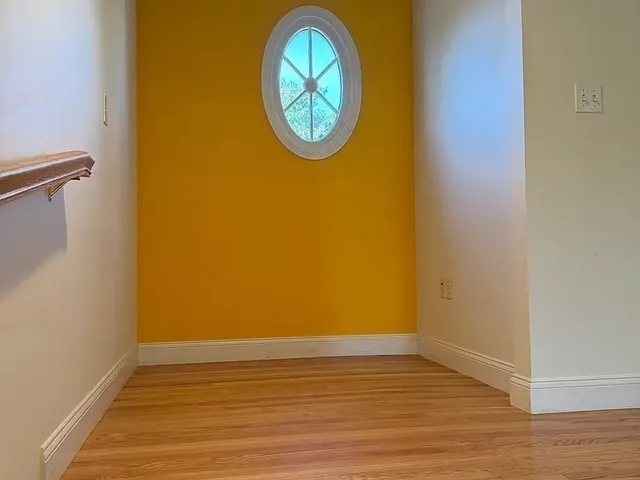 a view of room with wooden floor and a wall