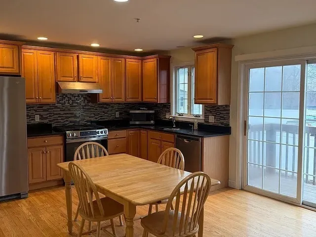 a kitchen with a table chairs sink and cabinets