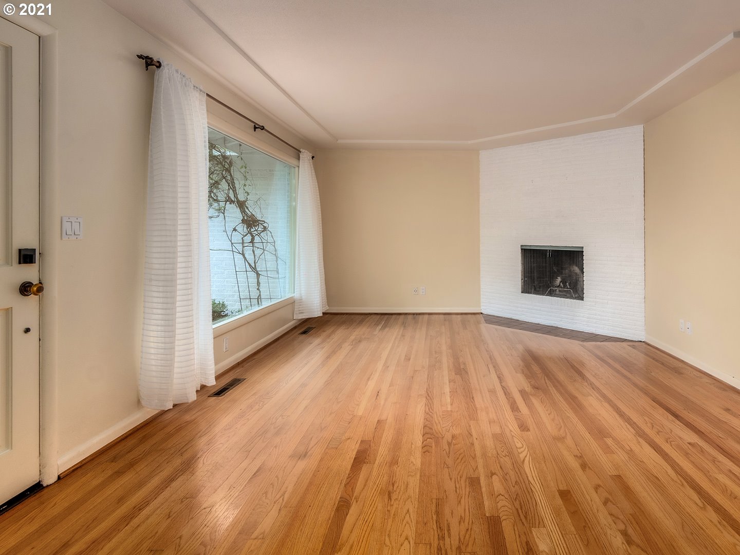 3480 Southwest Talbot Road Portland, OR 97239 - Photo 6 of 32 a view of an empty room with wooden floor and a window