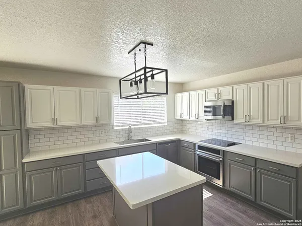 a kitchen with cabinets appliances a sink and a window