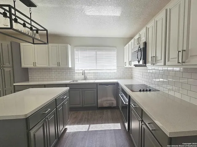 a kitchen with a sink stove top oven and cabinets