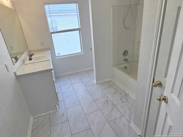 a bathroom with a bathtub sink and vanity