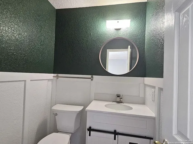 a bathroom with a sink mirror and toilet