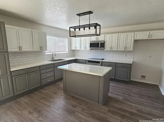 a kitchen with a sink cabinets and wooden floor