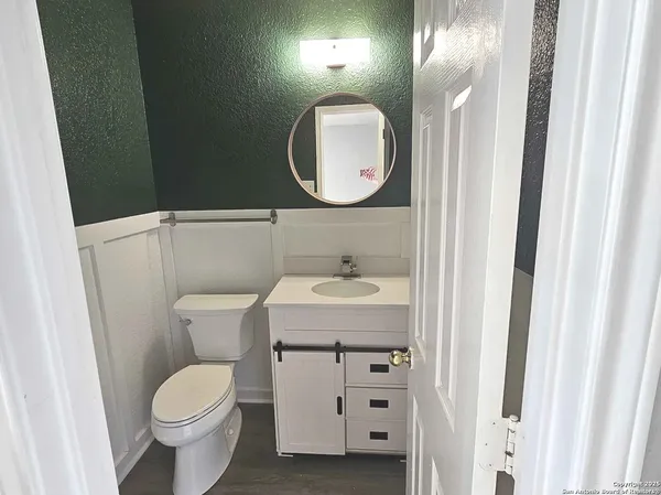 a bathroom with a toilet sink and mirror