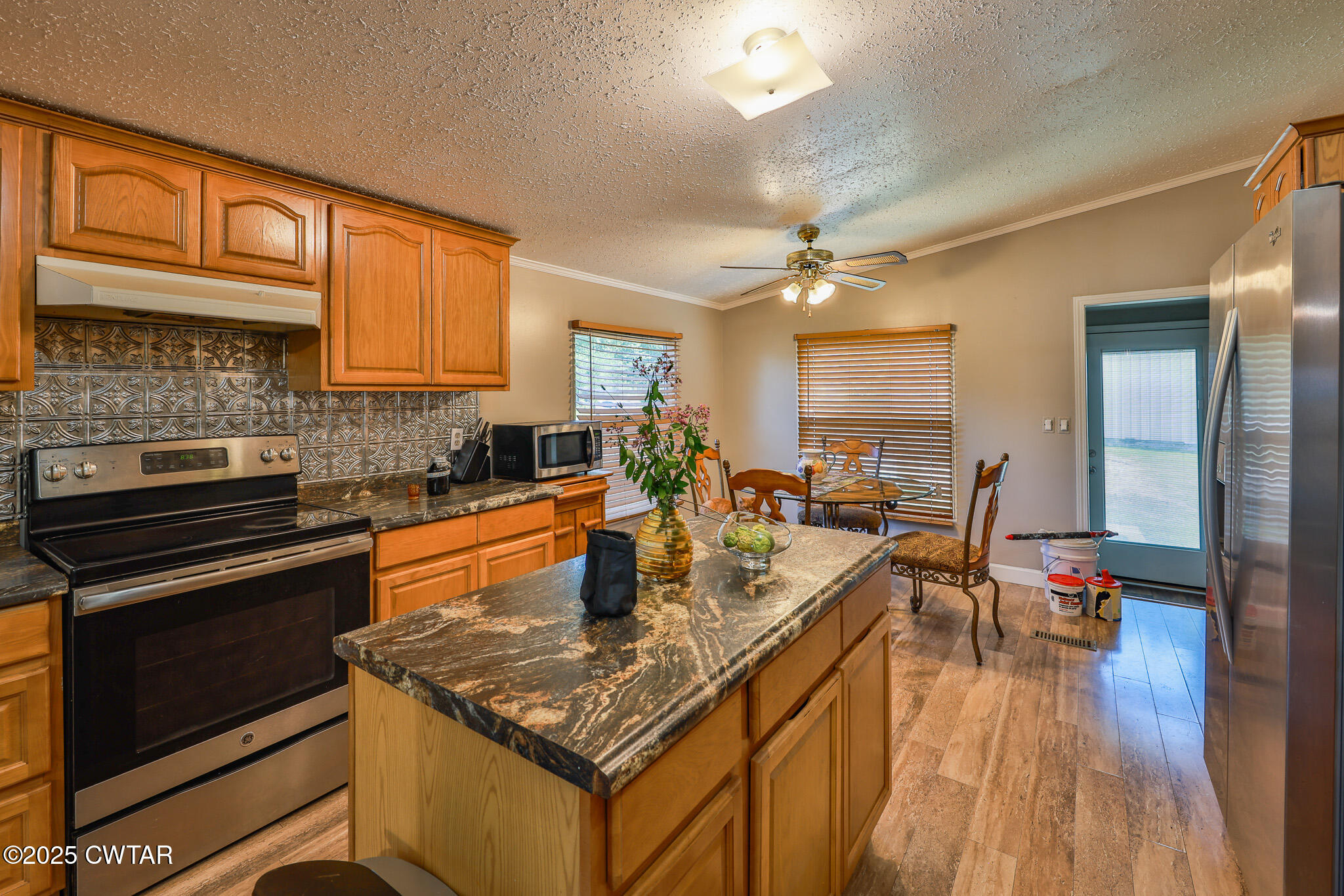 890 Snyder Road Martin, TN 38237 - Photo 14 of 33 a kitchen with a stove a sink dishwasher and a dining table with wooden floor
