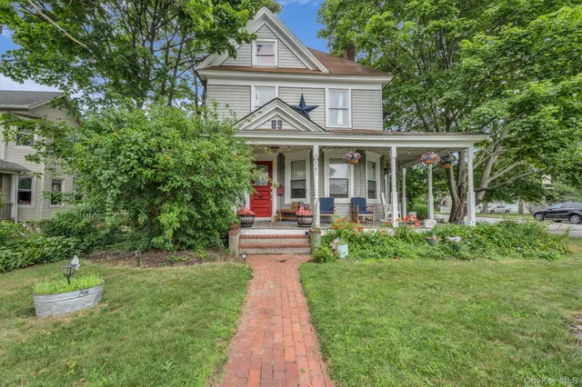 a front view of a house with a garden and plants