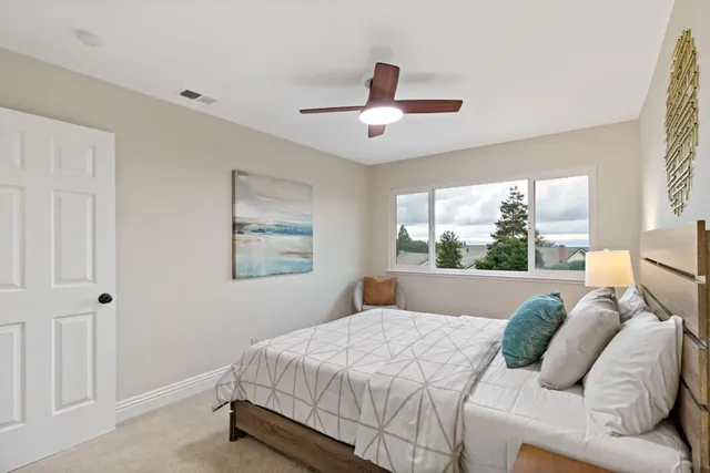 a bedroom with a bed and a painting on the wall