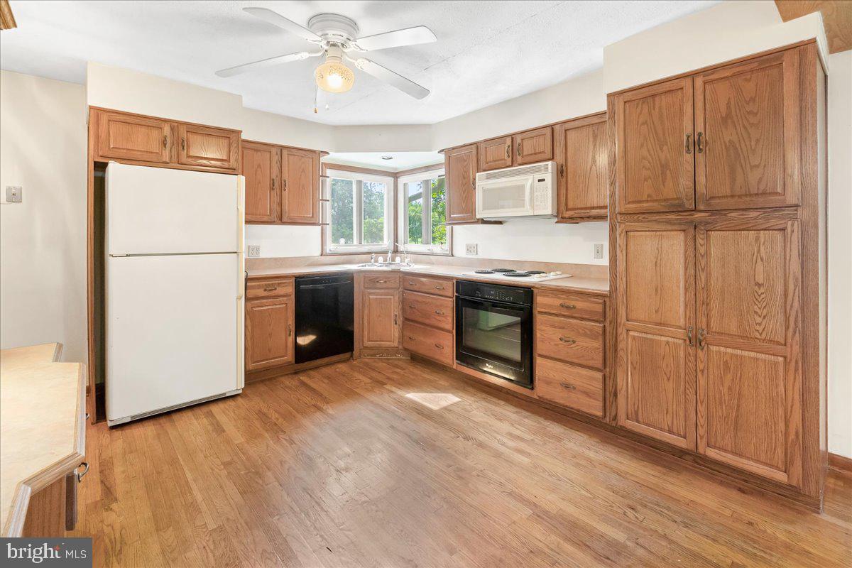 6010 Keysville Road Keymar, MD 21757 - Photo 11 of 64 a kitchen with stainless steel appliances granite countertop a refrigerator a sink dishwasher a stove with wooden cabinets and floors