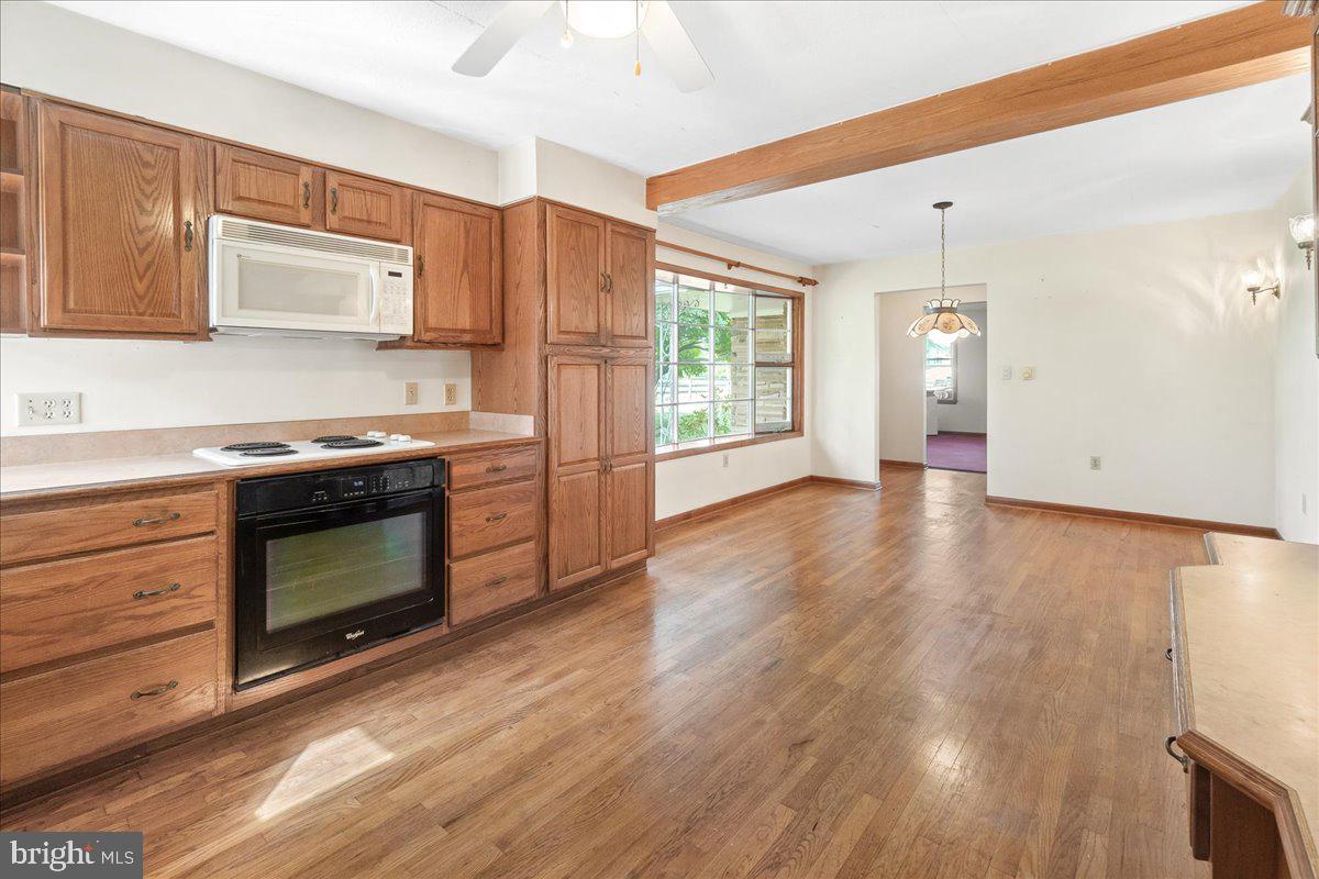 6010 Keysville Road Keymar, MD 21757 - Photo 8 of 64 a kitchen with granite countertop wooden floors stainless steel appliances and a window