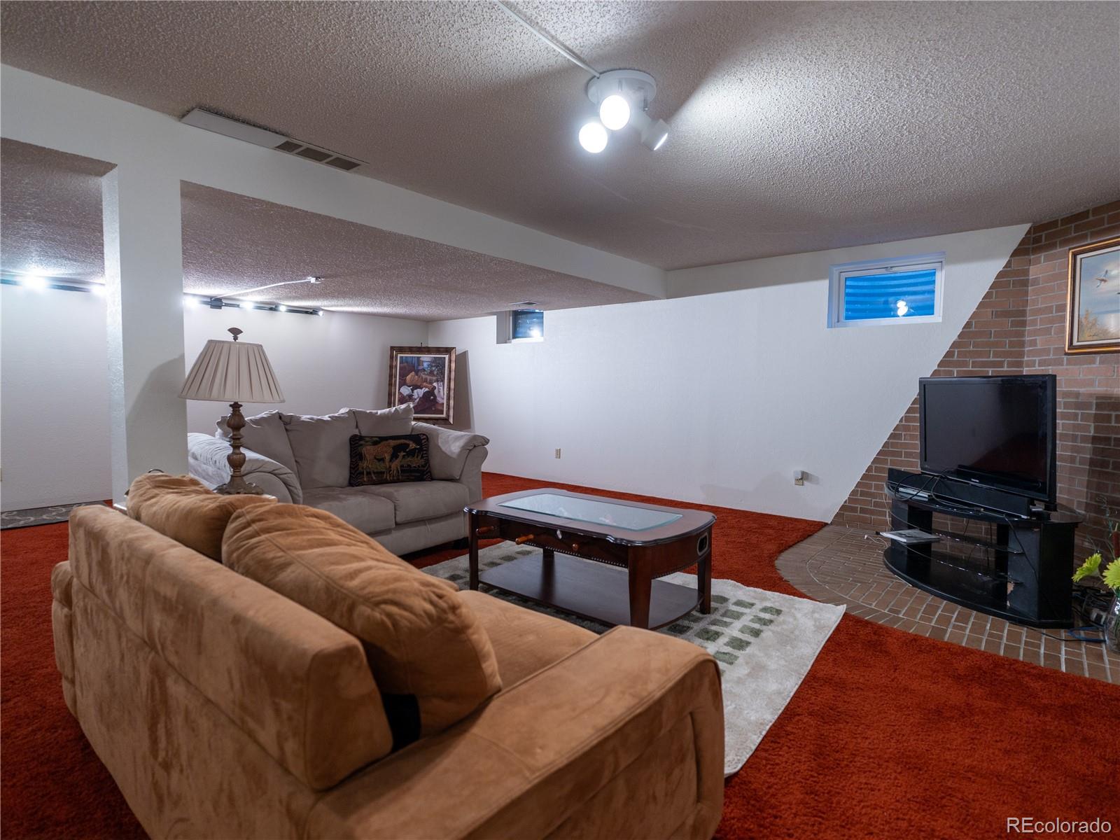 8908 Jellison Court Westminster, CO 80021 - Photo 13 of 17 a living room with furniture and a flat screen tv