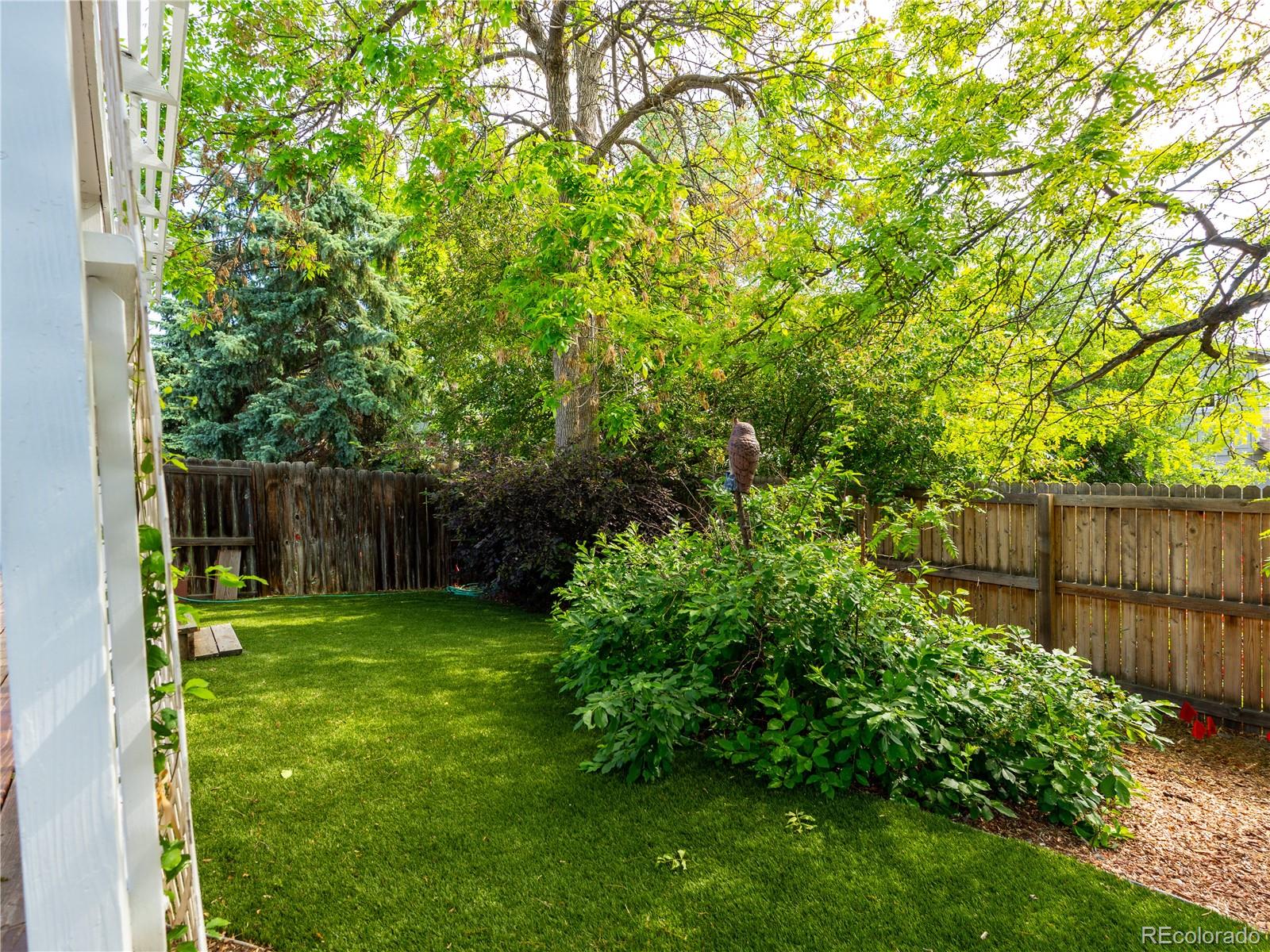 8908 Jellison Court Westminster, CO 80021 - Photo 15 of 17 a view of a backyard with plants and wooden fence