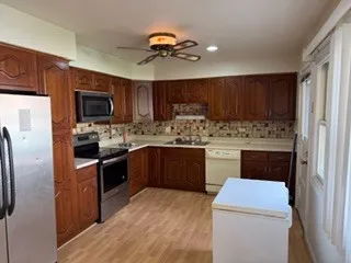 a kitchen with a refrigerator sink and cabinets
