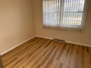a view of a room with wooden floor and windows