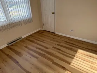 a view of a room with wooden floor and windows
