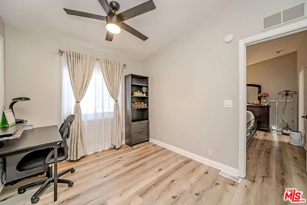 a view of a workspace with furniture and a window
