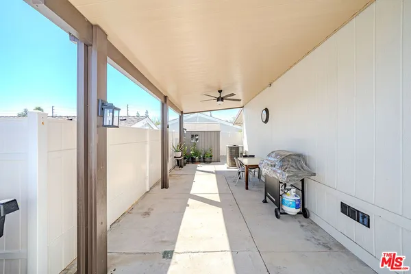 a view of a patio with table and chairs with wooden floor and fence