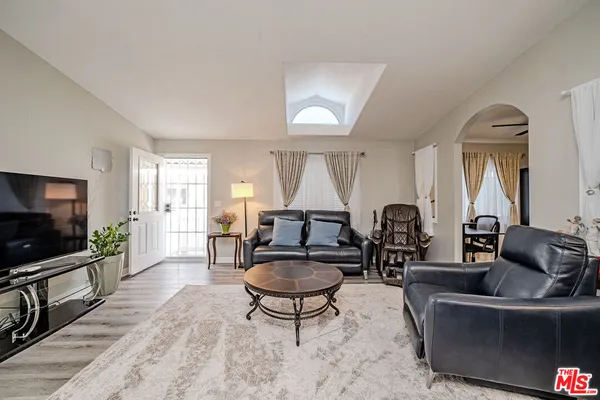 a living room with furniture a flat screen tv and a large window