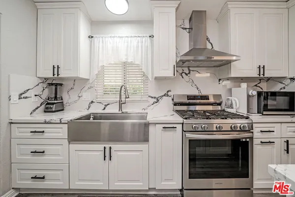 a kitchen with granite countertop a stove and a sink