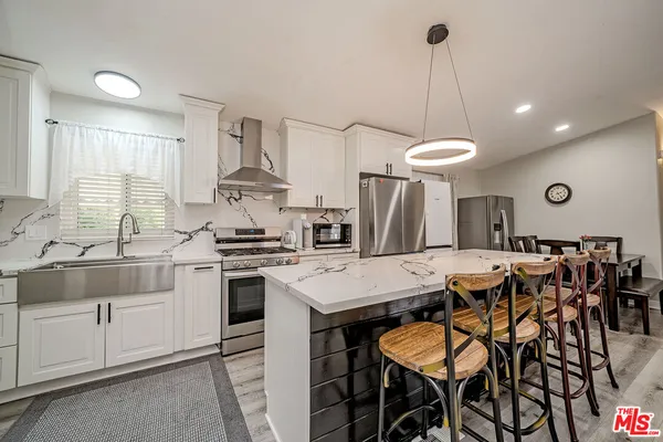 a kitchen with stainless steel appliances a stove a table and chairs