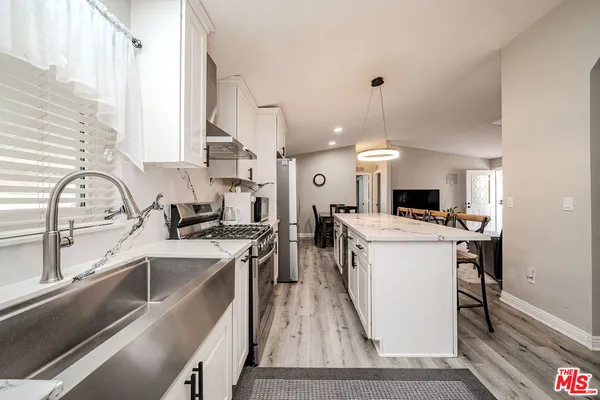 a kitchen with stove a sink and a refrigerator
